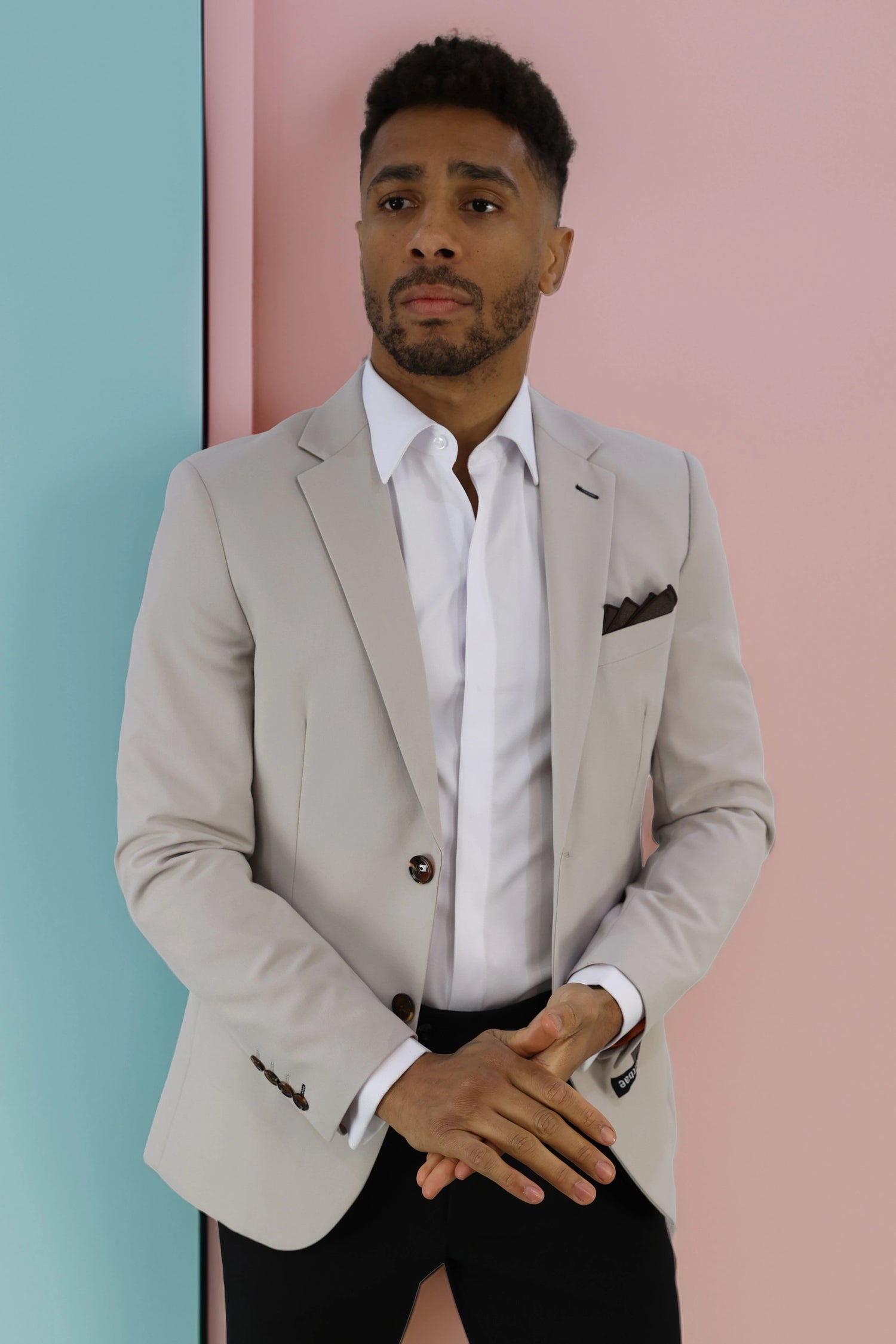Man wearing a tailored charcoal grey checkered suit with red detailing, paired with a white dress shirt and red pocket square. The stylish suit offers a modern, sophisticated look, perfect for weddings, business, and formal events.