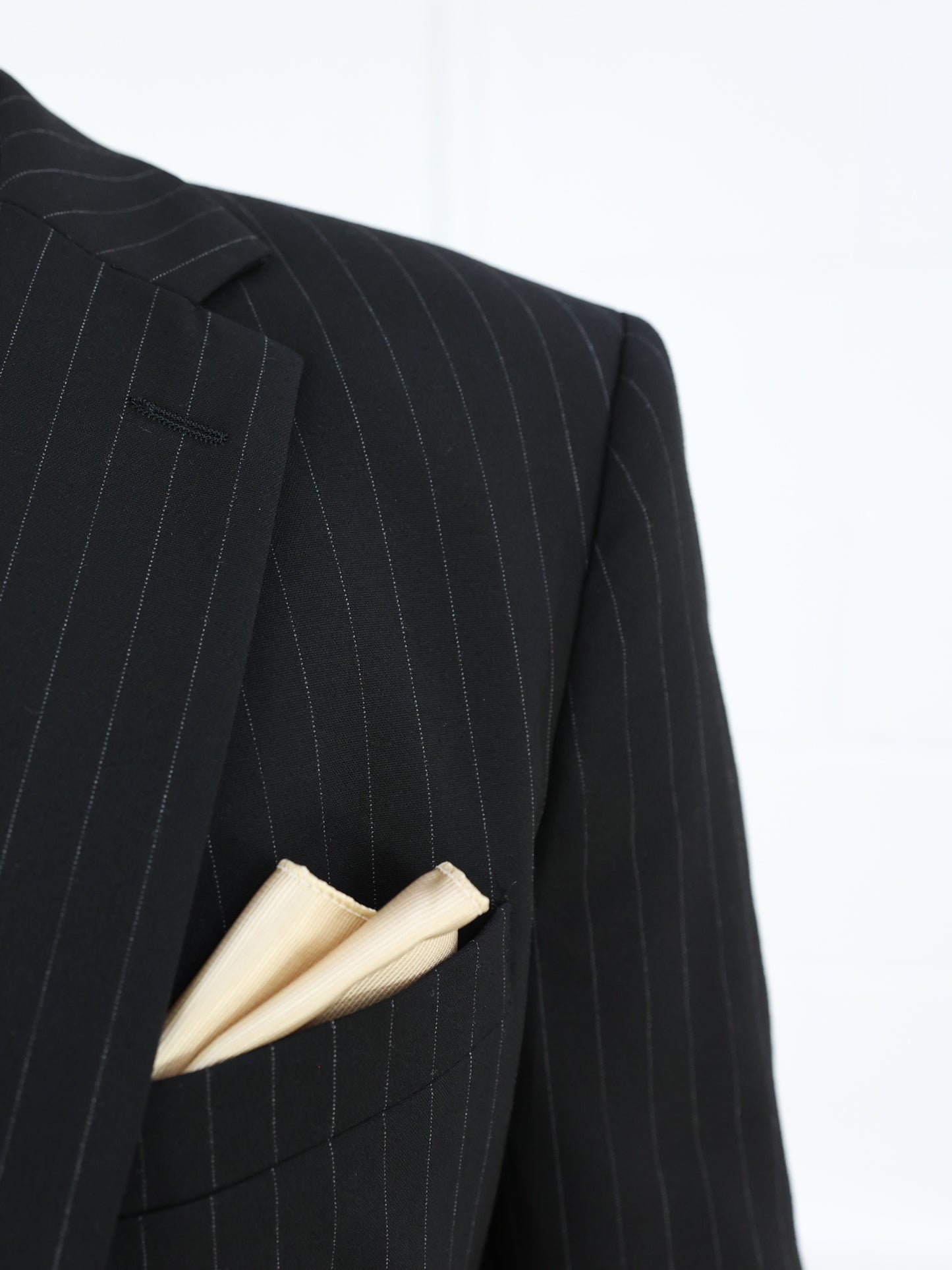 Close-up of the black pinstripe blazer lapel with a neatly folded gold pocket square, showcasing Suitbae's premium tailoring and attention to detail; available individually in skinny fit, slim fit, tailored fit, big & tall, XL, and larger men's sizes, perfect for formal and smart-casual occasions.