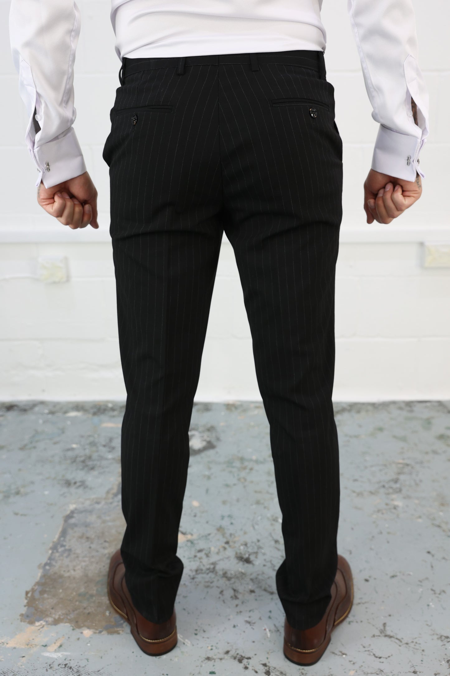 Rear view of Suitbae black pinstripe slim tailored fit tapered trousers, showcasing buttoned back pockets and a comfortable elastic waistband; sold individually, perfect for formal and smart-casual occasions.