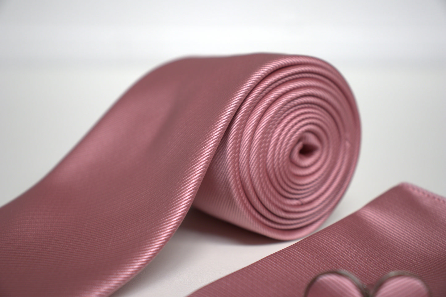 Detailed view of mauve pink satin tie with rolled fabric, elegant men’s wedding and prom accessory