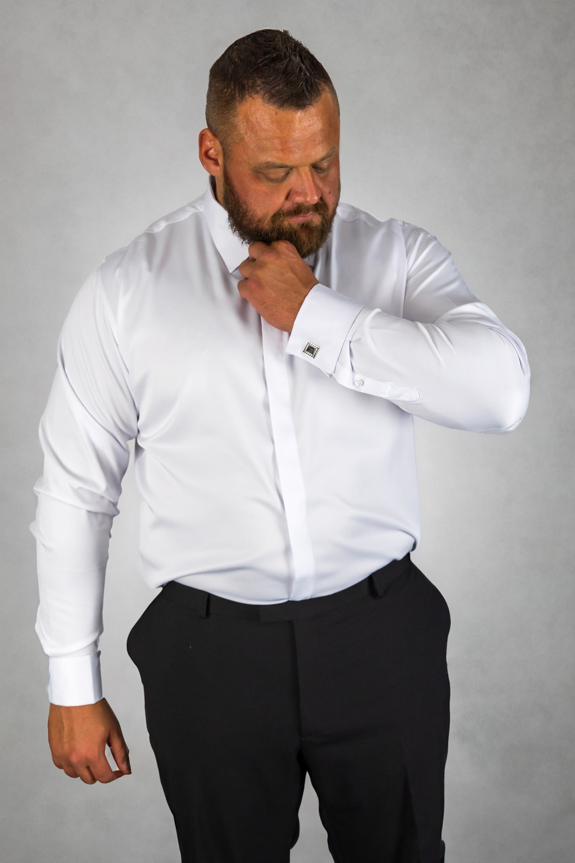 Man wearing a white long-sleeve dress shirt paired with black trousers, featuring cufflinks and a modern tailored fit. The formal shirt is ideal for business, weddings, and special occasions, offering a sharp, polished look.