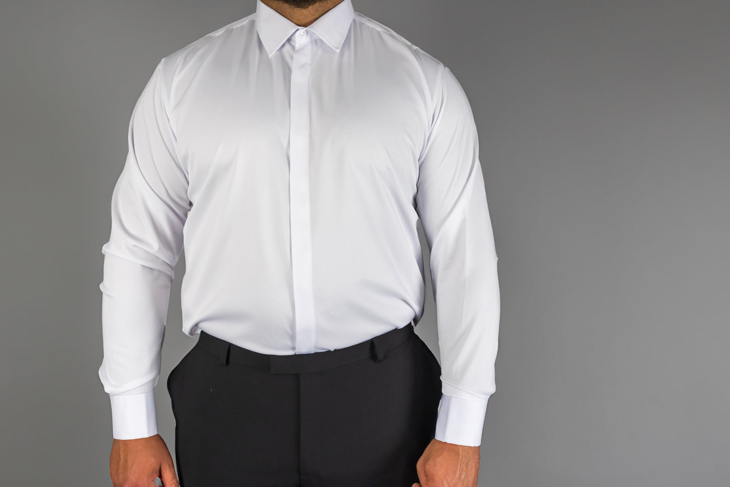 Man wearing a white dress shirt with black trousers, featuring a classic collar and button-down front. The formal shirt offers a clean, professional look, perfect for business, weddings, and formal events.