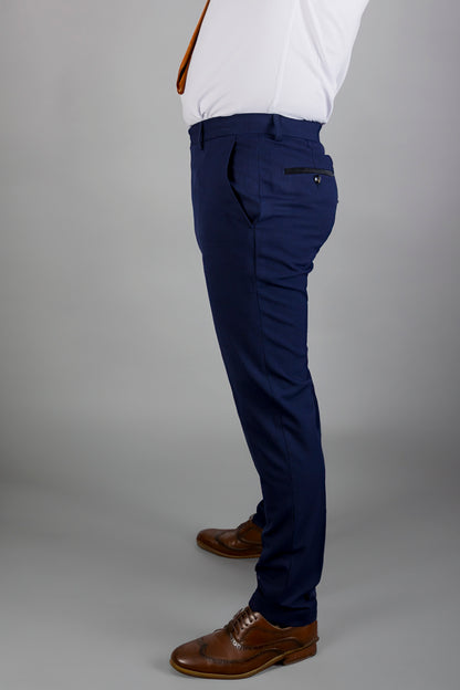 This side profile image shows a well-tailored pair of navy trousers, styled with brown leather shoes. The trousers fit snugly and are paired with a white dress shirt and a vibrant orange tie, creating a sharp, sophisticated look. The back pocket details and precise fit of the trousers enhance the modern and polished style, perfect for formal events or business settings. The outfit showcases a seamless blend of classic and contemporary men's fashion.