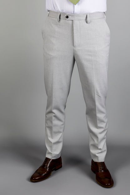  Front view of Suitbae Charles stone trousers, featuring a subtle Prince of Wales check pattern in a modern slim-fit cut. The trousers include a single front button closure and belt loops, paired with classic brown brogue shoes, showcasing a sharp and sophisticated look for formal occasions.