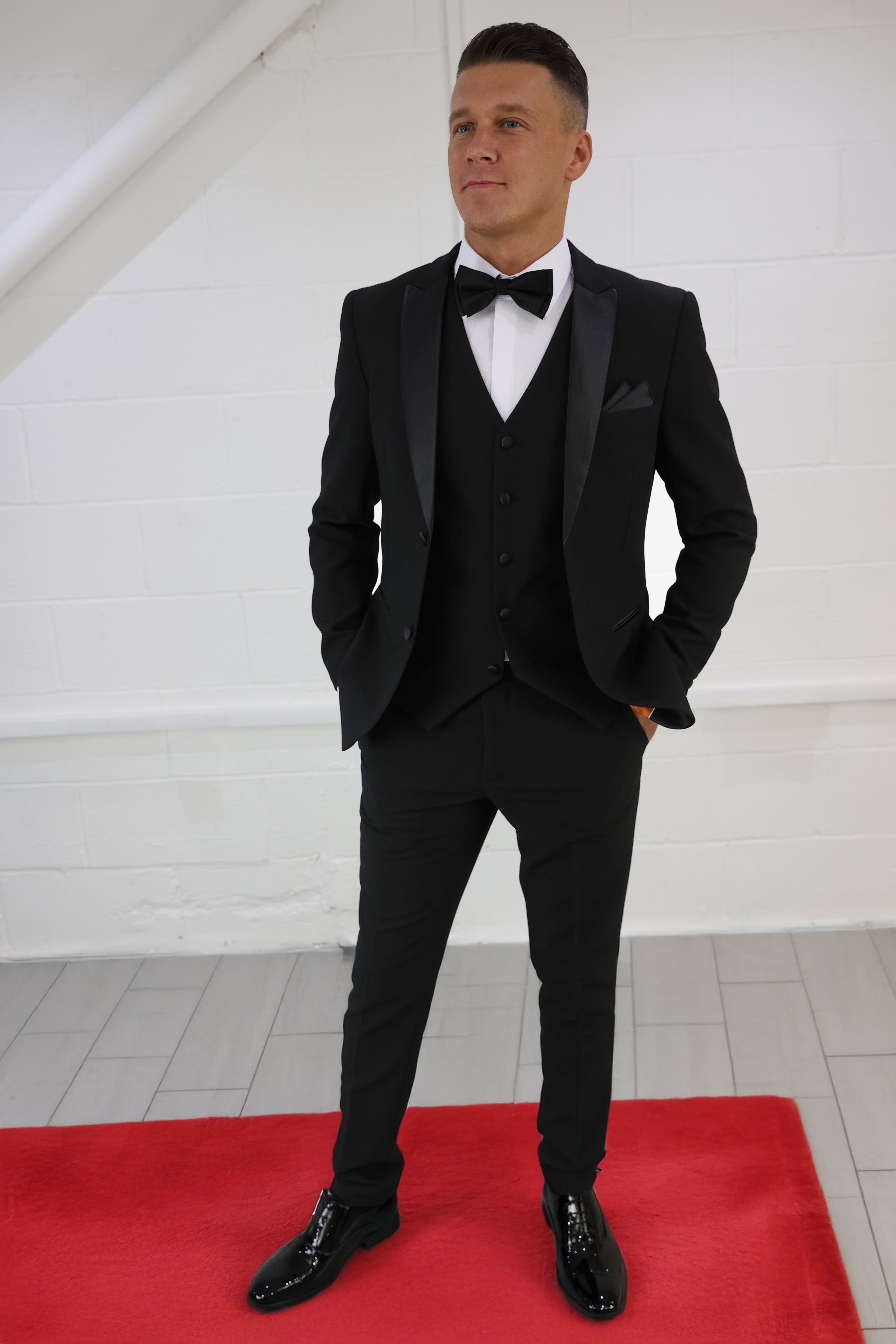 Model wearing a classic black tuxedo from SUITBAE for a black tie event.