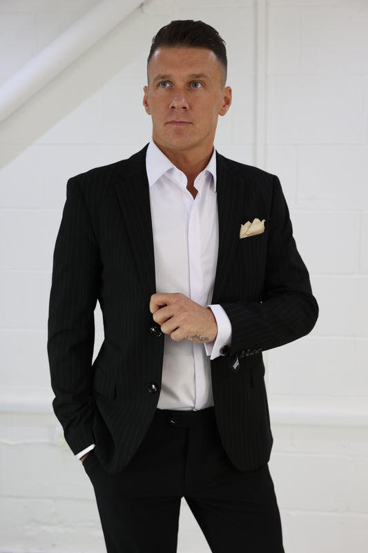 Man wearing a black pinstripe blazer styled with a crisp white shirt and gold pocket square; a versatile piece from Suitbae, available individually in skinny fit, slim fit, tailored fit, big & tall, XL, and larger men's sizes, perfect for formal or smart-casual occasions.