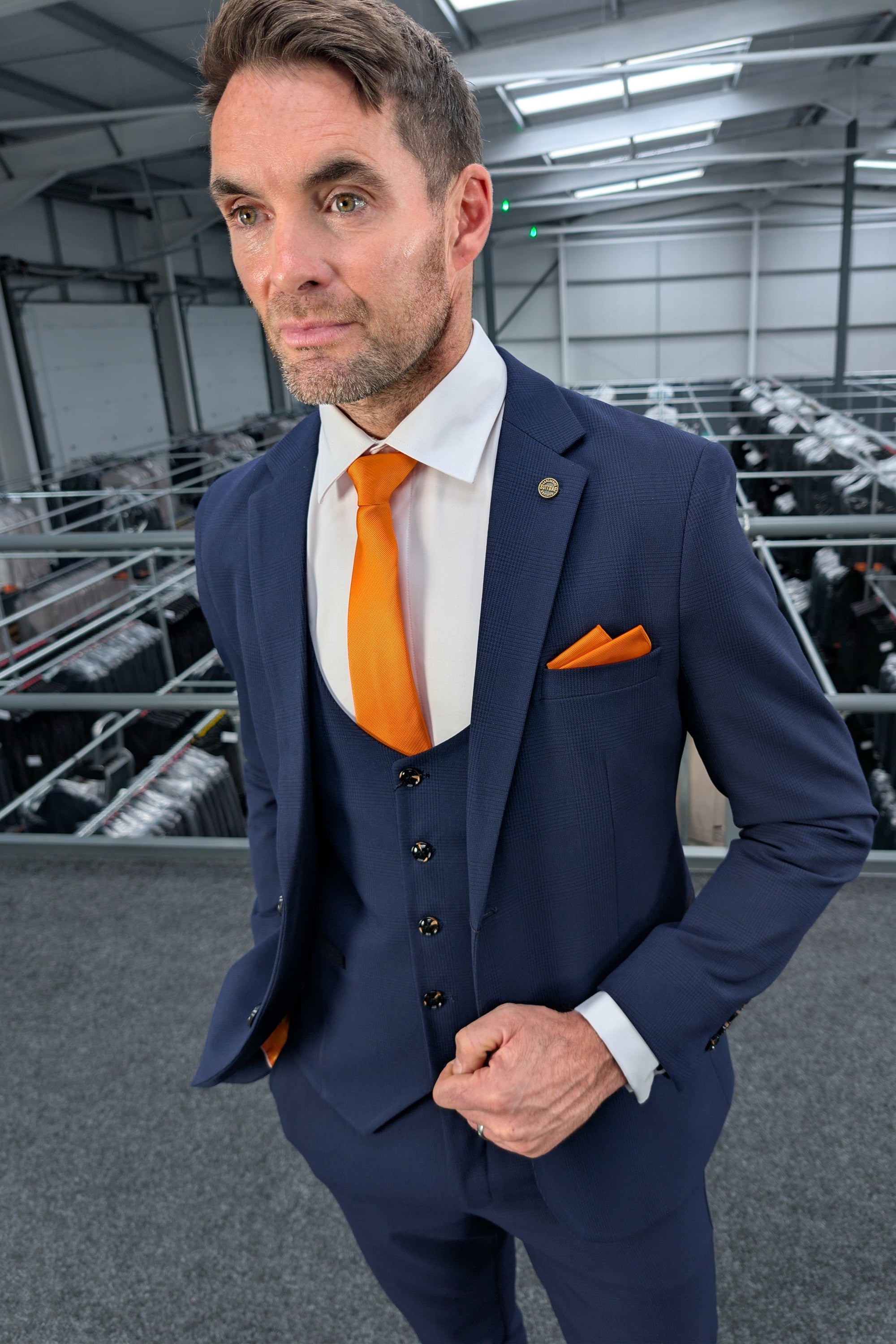 • Man styling a navy three piece cocktail suit with a subtle check pattern from SUITBAE