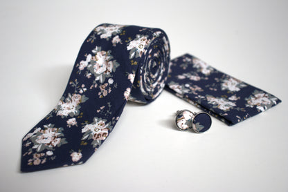 Close-up of navy floral tie with pocket square and cufflinks, stylish accessory set for grooms and formal occasions