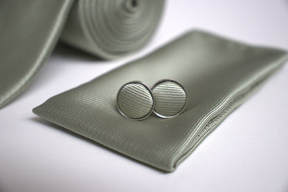 Close-up of sage green pocket square and cufflinks, elegant groomsmen accessories for prom, races and special occasions.