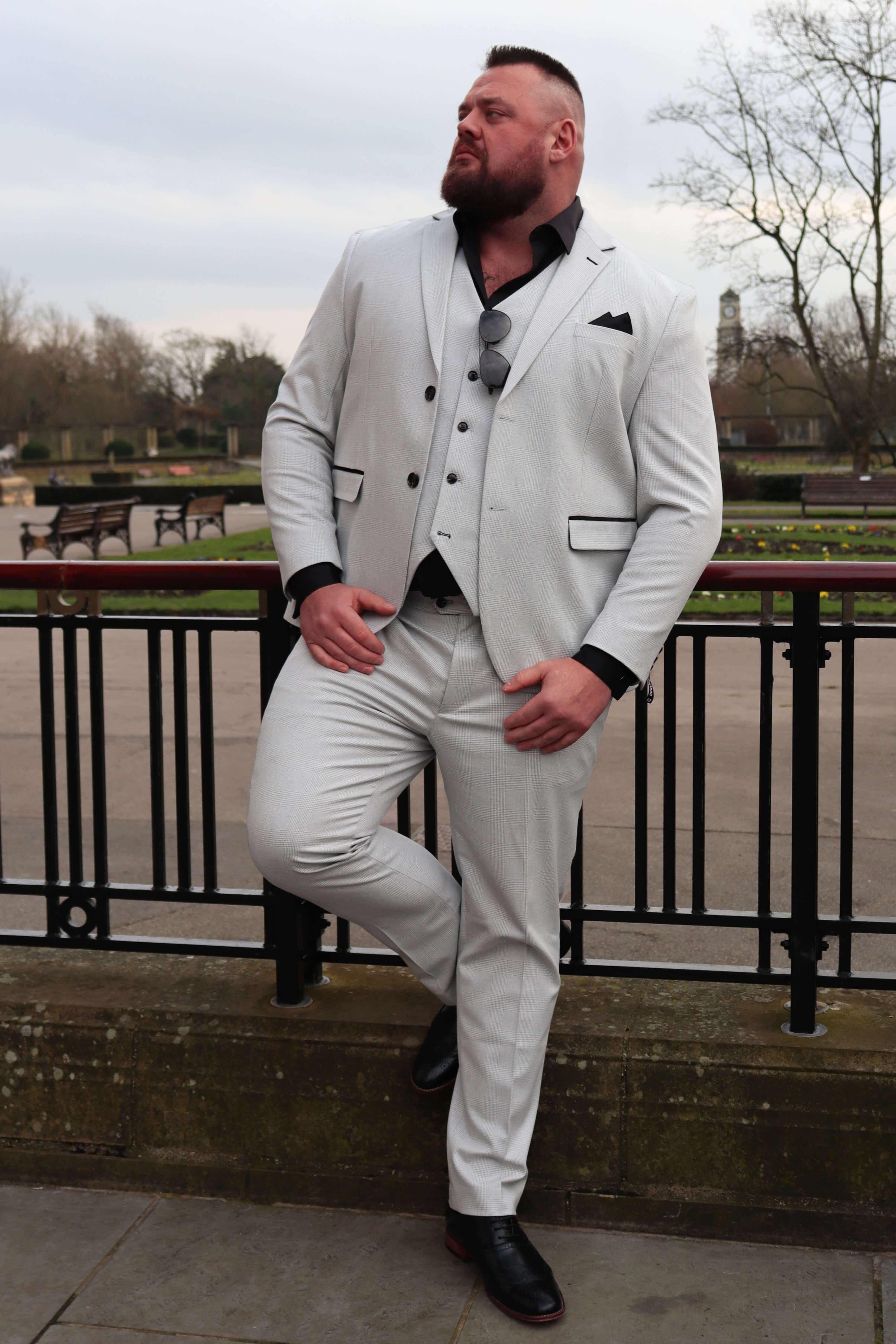 Big and tall wedding guest wearing the SUITBAE Charles Stone Three-Piece Suit in a light stone grey fabric.
